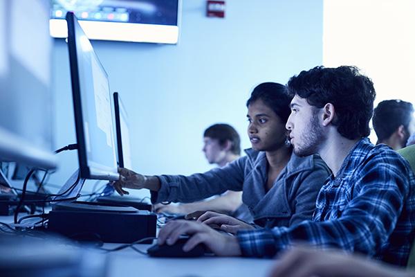 three data science students working in a computer lab