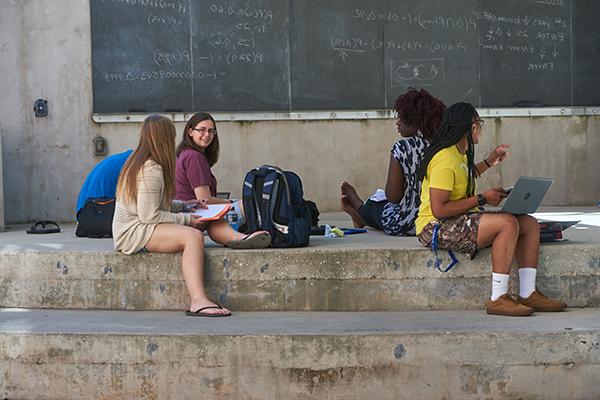 mathematical sciences students studying on a chalkboard outside of uwf building 4